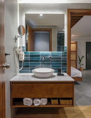 A modern bathroom with a large mirror, a white sink, and a wooden vanity. - Amyntas Seafront Hotel (Sithonia)