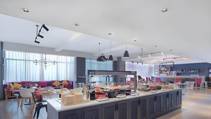 A modern kitchen area with a central island, dining table, and chairs. - Campanile Hotel Shenzhen Honghuashan Metro Station (Shenzhen)