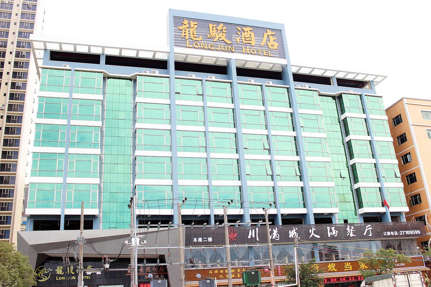 A hotel with a modern facade, multiple floors, and a prominent sign.