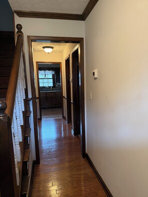A wooden staircase leading to a kitchen area with a window.
