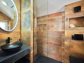 A modern bathroom with a round mirror, a black sink, and a shower area. - Hedera Estate, House Hedera II (Dubrovnik)