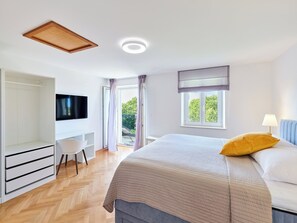 A bedroom with a bed, a desk, a television, and a window. - Hedera Estate, House Hedera II (Dubrovnik)