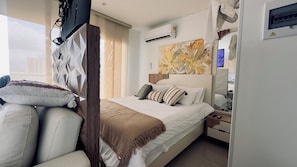 Een hotelkamer met een bed, nachtkastje en een spiegel.