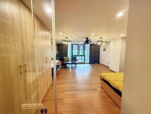 Quarto com cama, mesa de jantar com cadeiras, sofá e ventilador de teto.