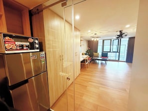 A kitchen with a stainless steel refrigerator, wooden cabinets, and a dining area with a table and chairs. - TMH HOUSE 03 LVT Hotel & Apartment (Son Tra)