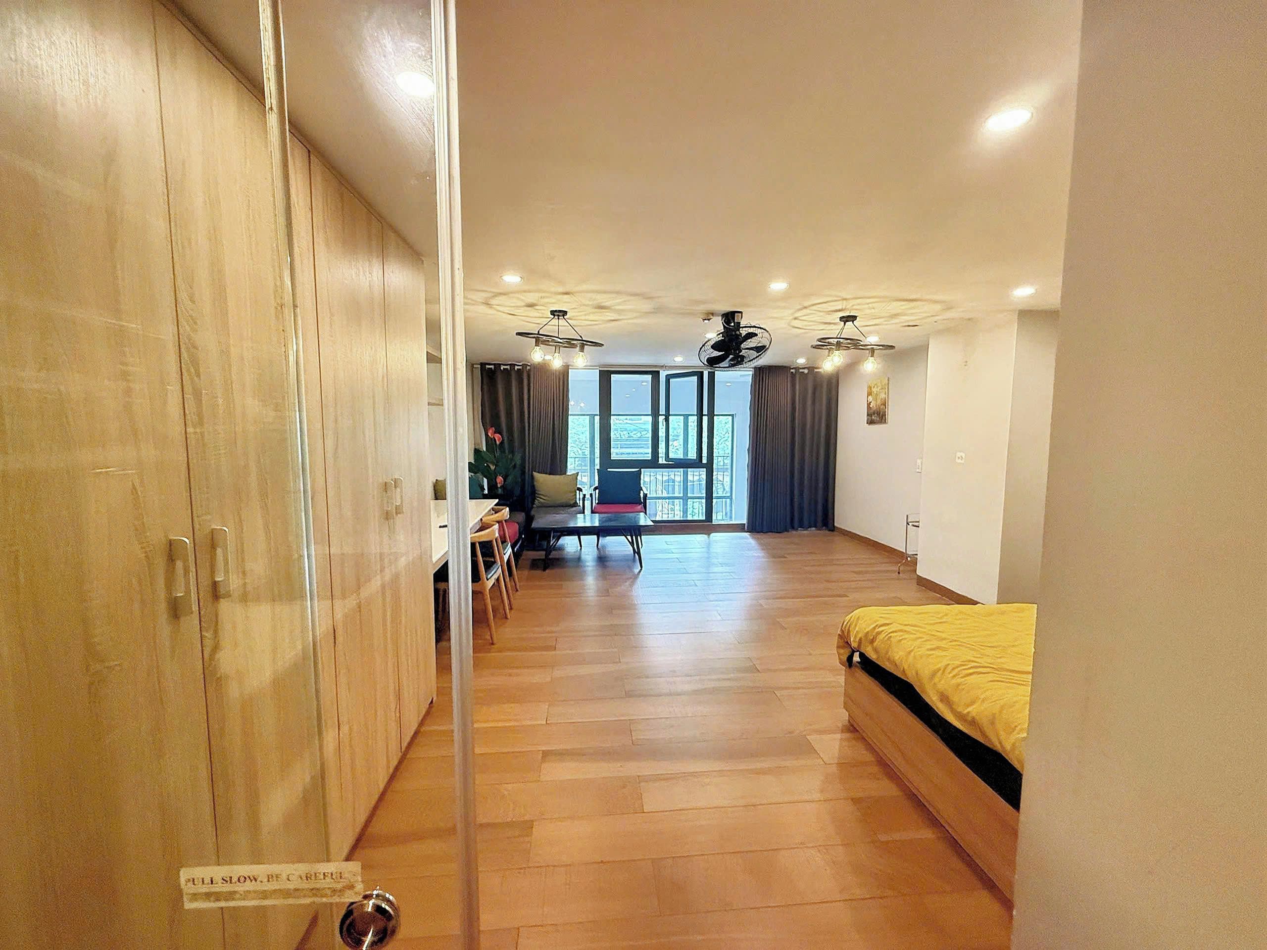 A room with a bed, a dining table with chairs, a sofa, and a ceiling fan.