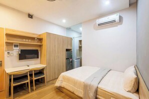Quarto com cama, escrivaninha e guarda-roupa.