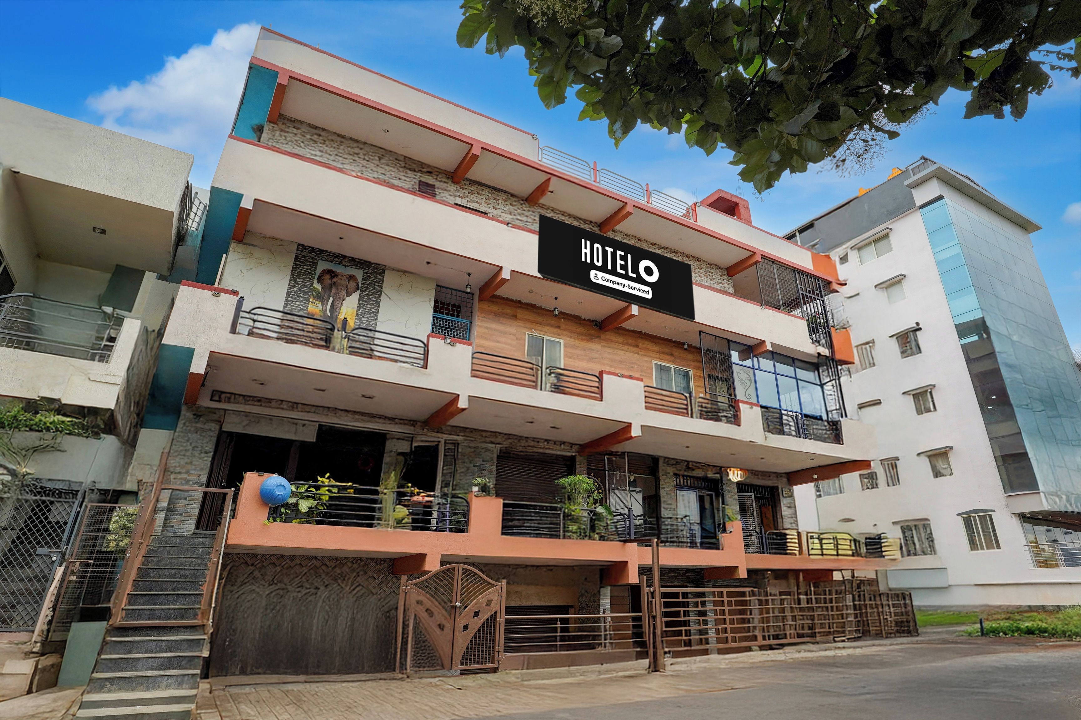 A multi-story hotel with a prominent 'HOTEL' sign, balconies, and a gated entrance.