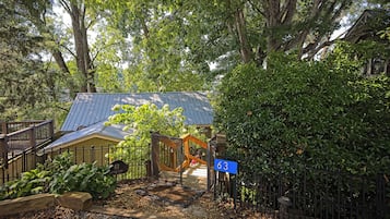 A residential property with a metal gate, a wooden fence, and a house with a blue roof.