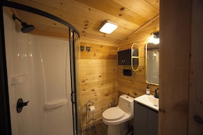 A wooden cabin bathroom with a shower, toilet, and sink. - Mini Messer - Downtown, Walk to Shops (Blue Ridge)