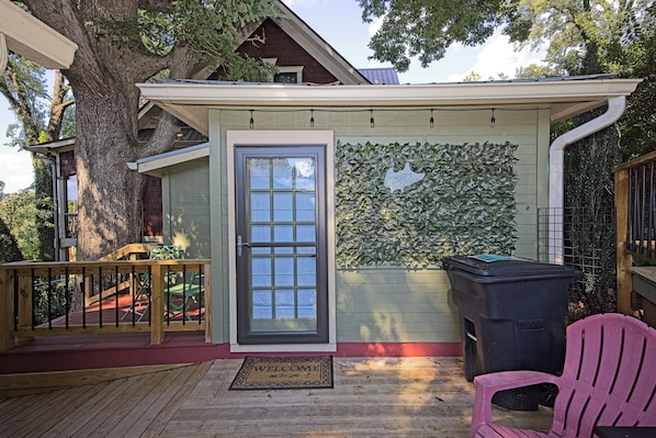 A covered outdoor area with a door, a bench, a trash bin, and a wall covered in foliage. - Mini Messer - Downtown, Walk to Shops (Blue Ridge)
