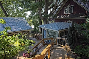 A wooden deck with a staircase leading to a covered area, surrounded by trees and a house with a metal roof. - Messer Loop Hideaway - Downtown, Walk to Shops (Blue Ridge)