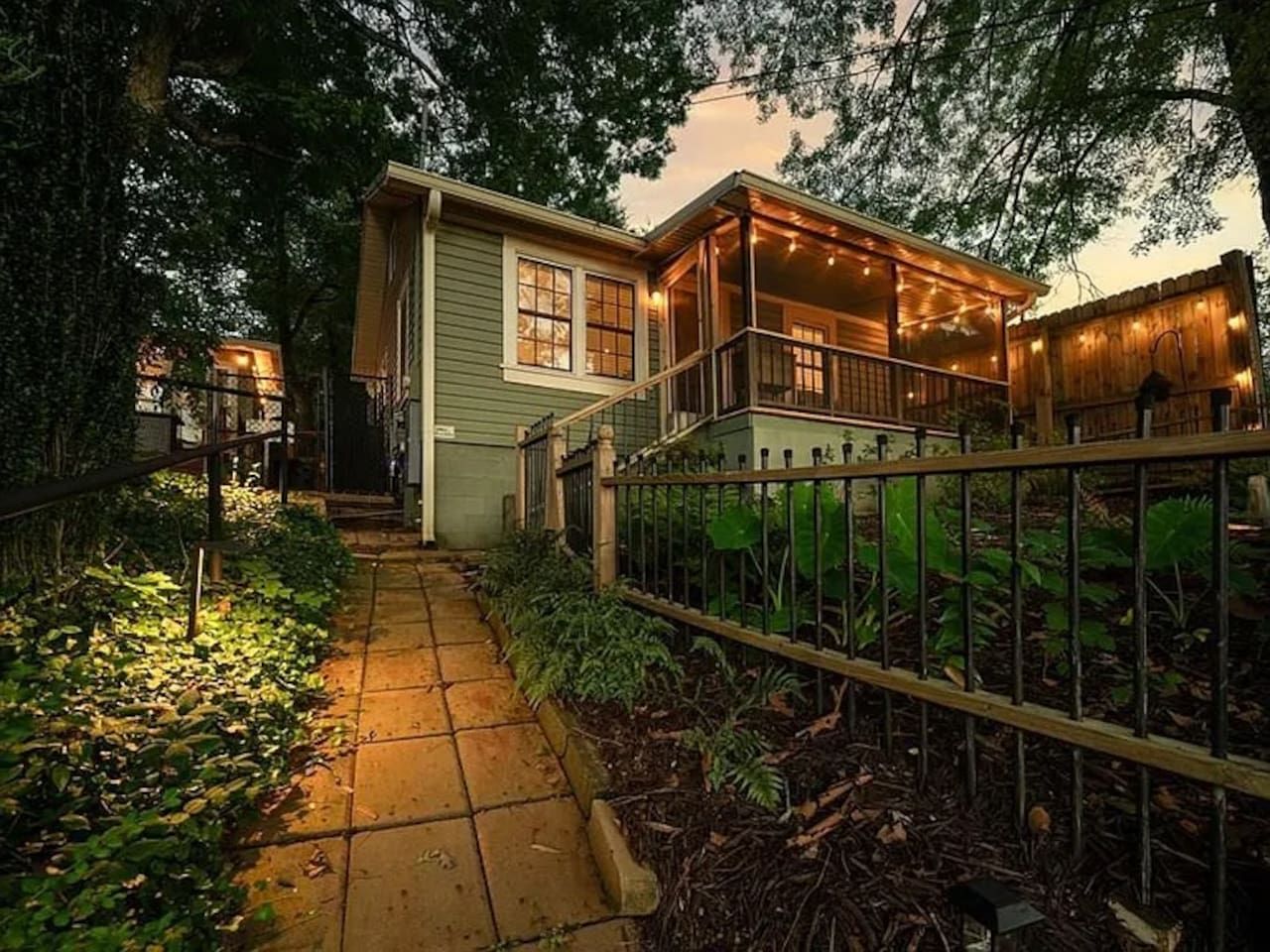 A house with a porch, a pathway, and a fence.