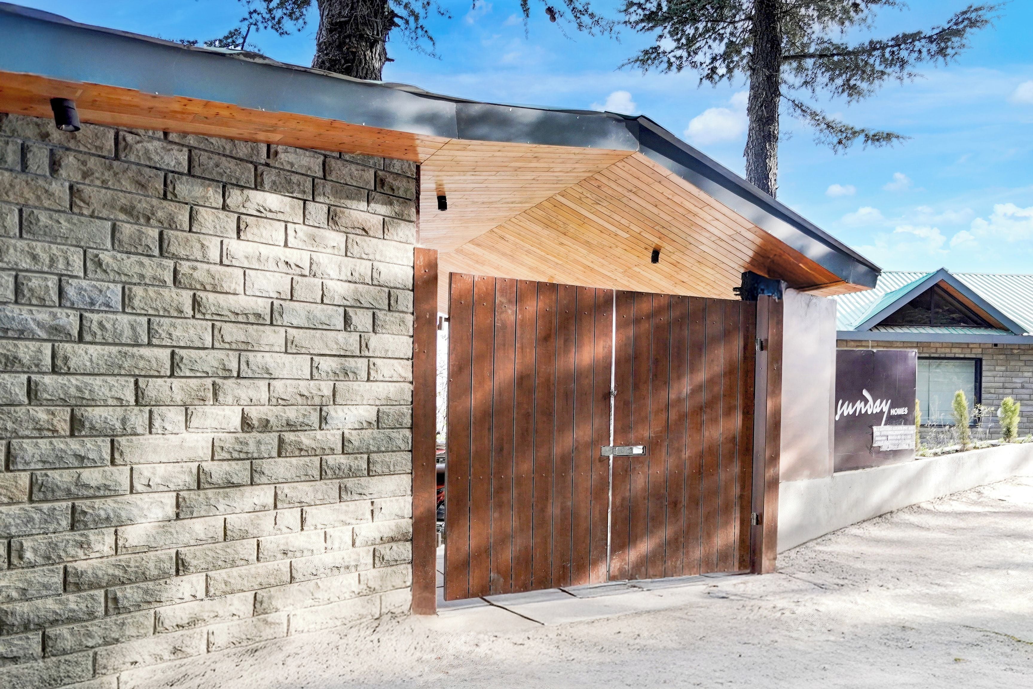 A building with a brick facade, a wooden door, and a metal roof.