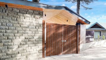 A building with a brick facade, a wooden door, and a metal roof.