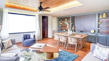 Una sala moderna con comedor, techo de madera y estanterías empotradas con objetos decorativos.