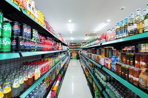 A supermarket aisle with shelves stocked with various beverages and snacks. - Viet Apartments (Da Nang)