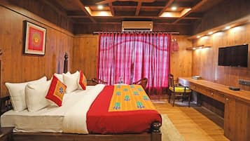 Una habitación de madera con una cama, un escritorio y un televisor.