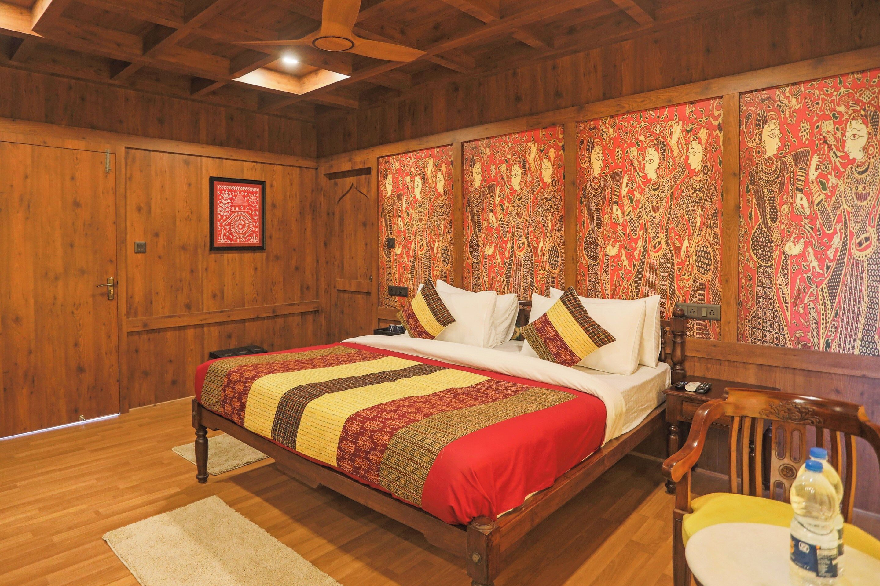 A wooden-paneled bedroom with a bed, pillows, a nightstand, and a chair.