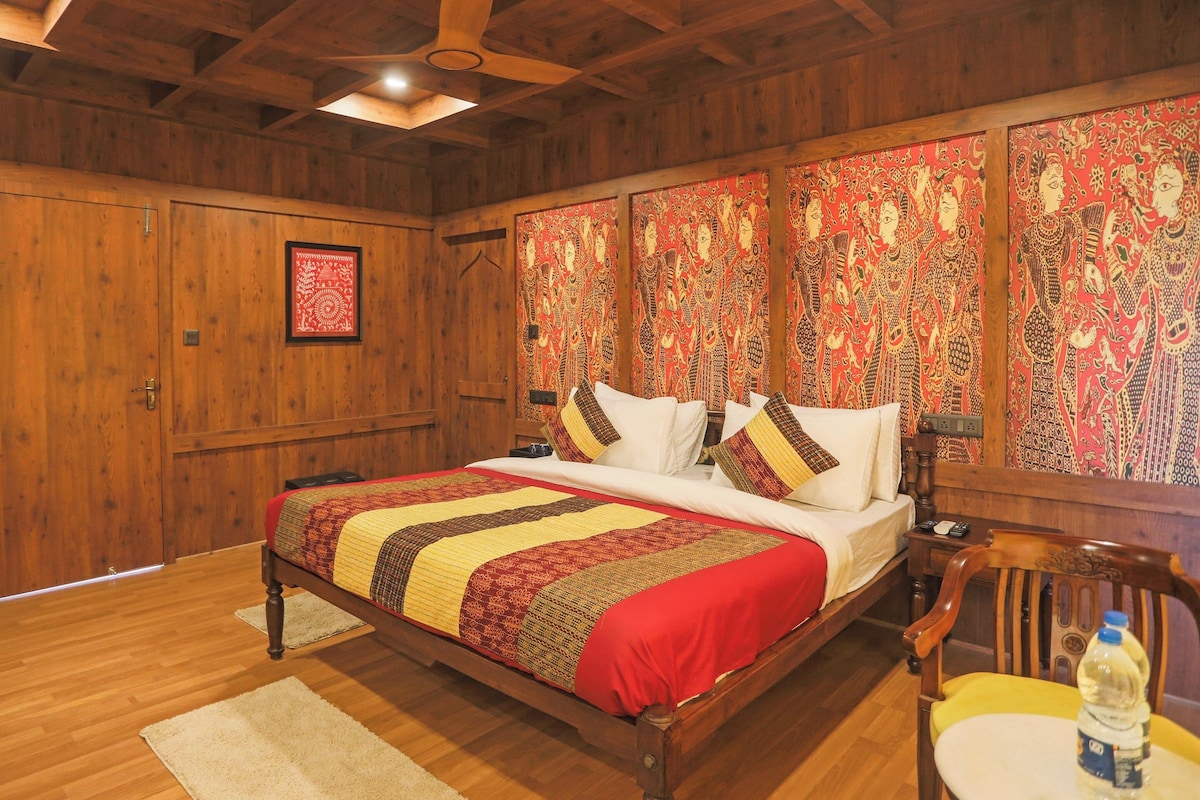 A wooden-paneled bedroom with a bed, pillows, a nightstand, and a chair.