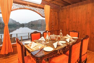 A dining table set for six with a view of a lake and hills.