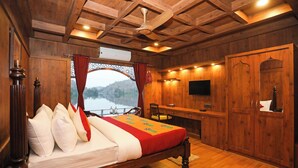 A wooden room with a bed, a desk, a television, and a wardrobe. - Ekta Houseboat Statue Of Unity Kevadia (Vadodara)