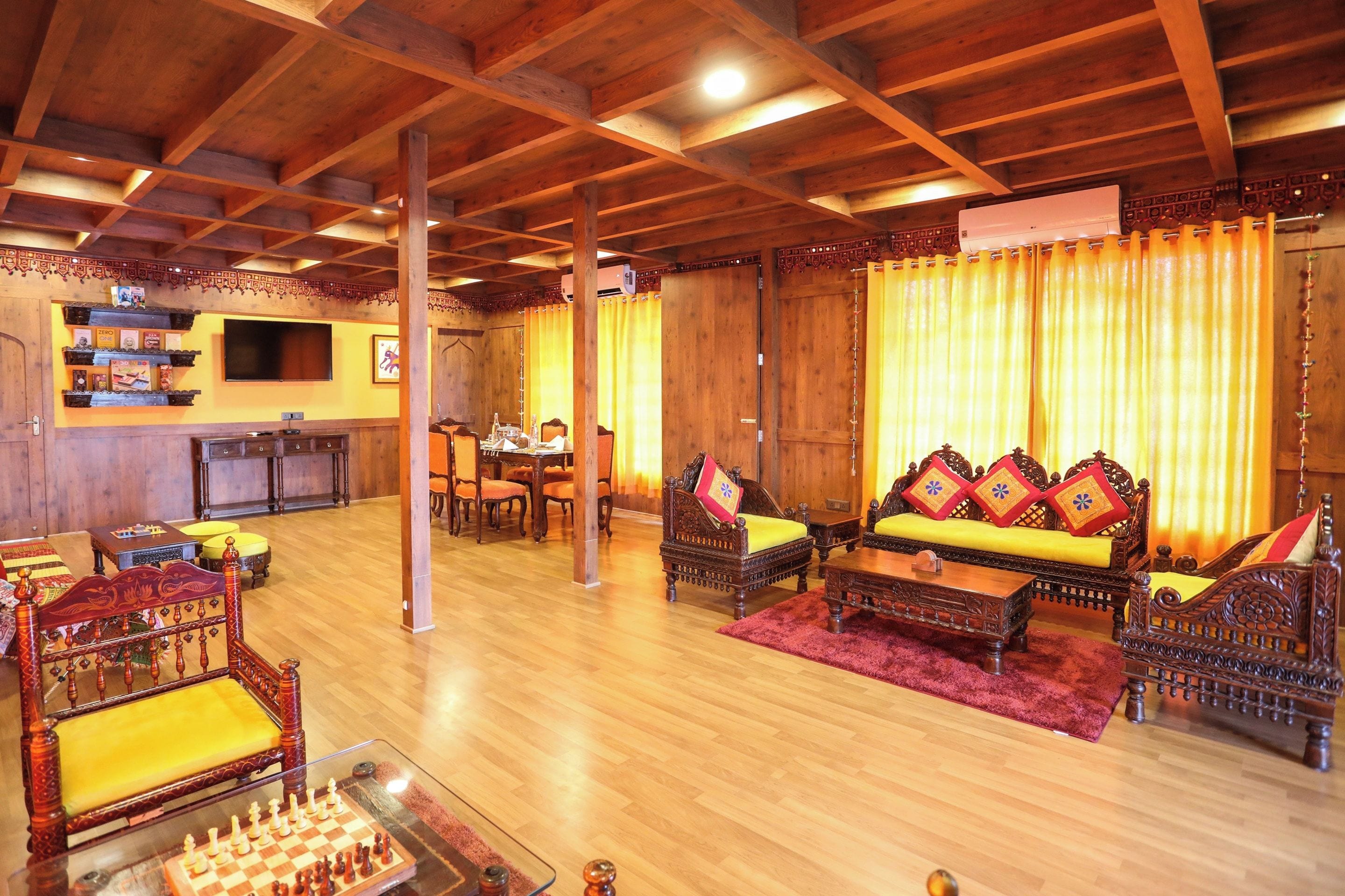 A cozy room with wooden furniture, a chessboard, and a television.