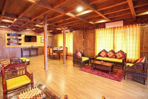 A cozy room with wooden furniture, a chessboard, and a television.