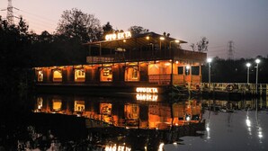 A houseboat with a sign reading 'OYO EKTA' and 'ATYOEKTA' reflecting on the water. - Ekta Houseboat Statue Of Unity Kevadia (Vadodara)