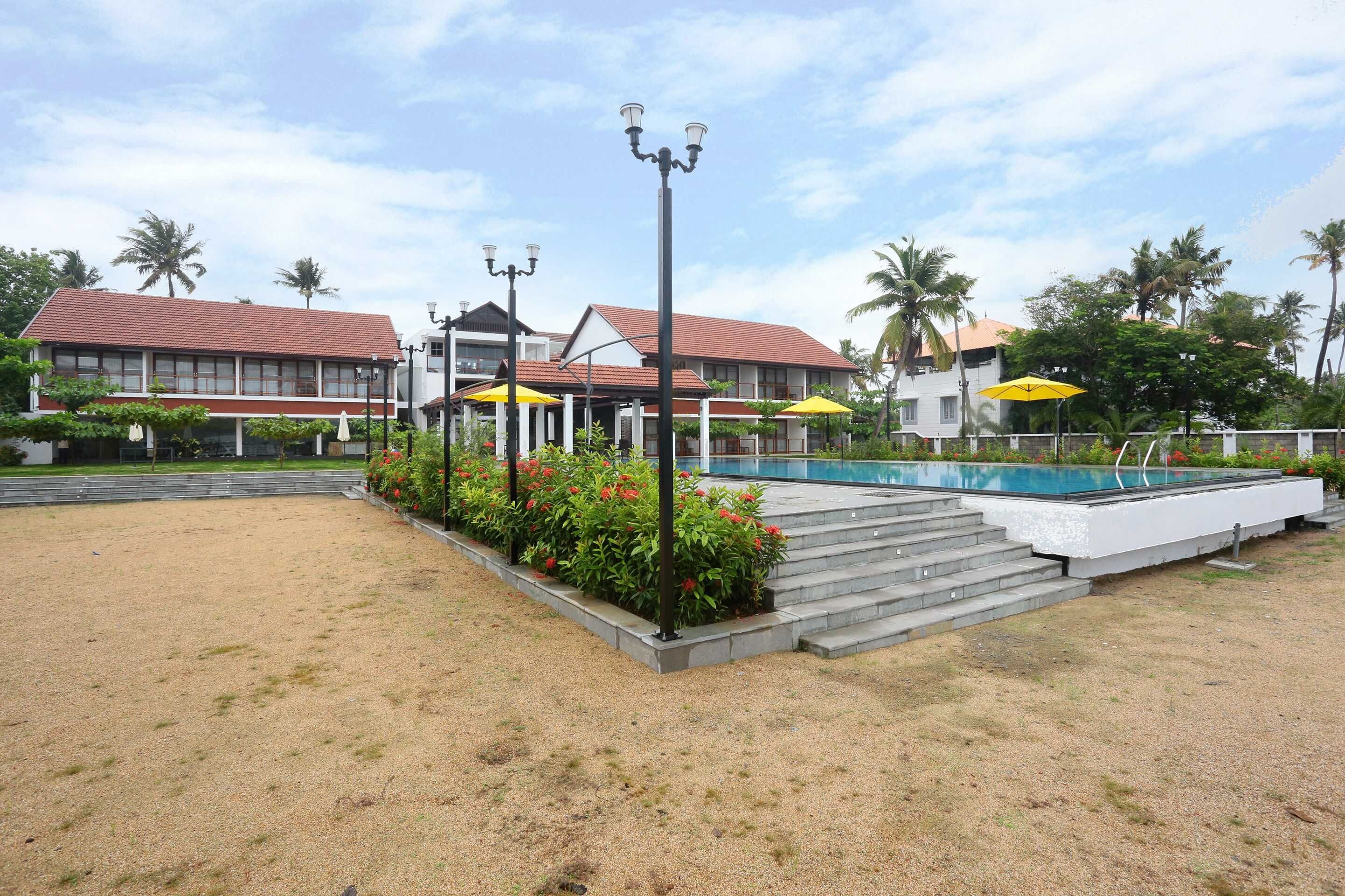 A hotel with a swimming pool, outdoor seating, and a garden area.