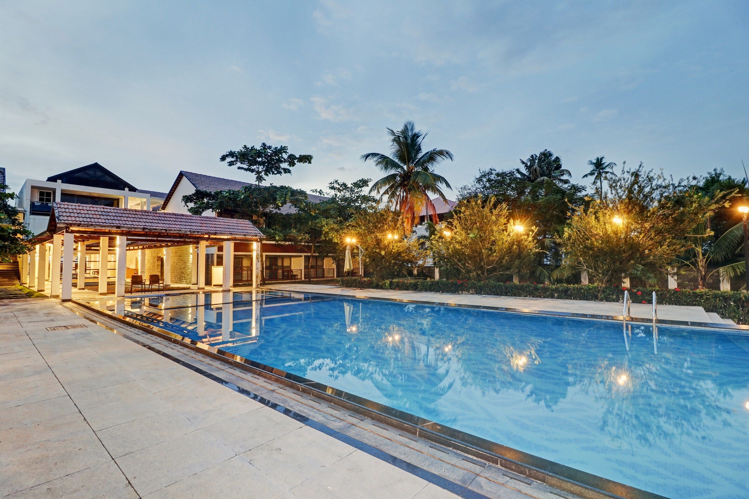 A swimming pool with a sunken seating area and a covered pavilion.