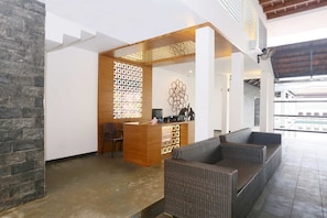 A reception area with a reception desk, seating, and a decorative wall.