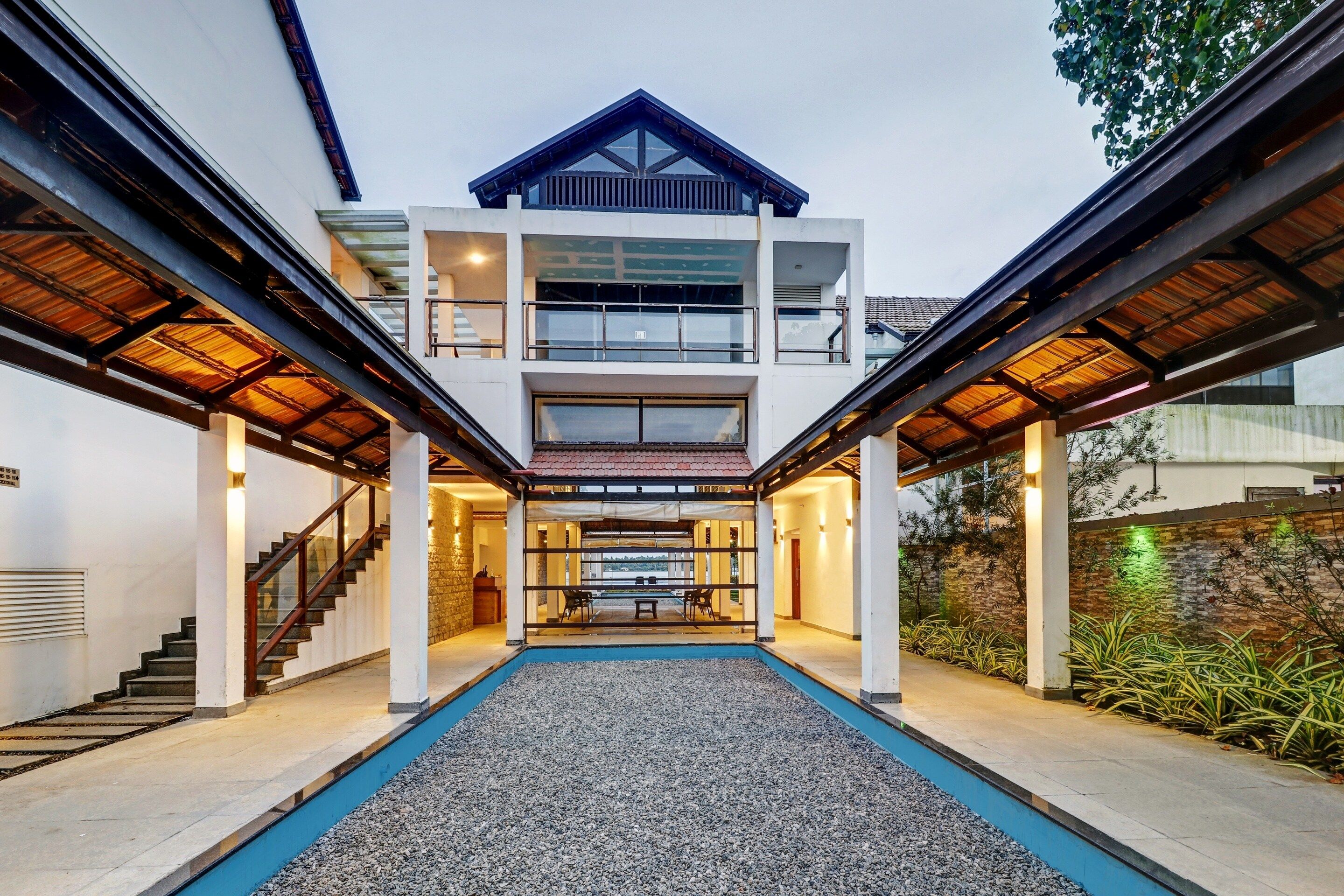 A modern multi-story building with a central courtyard, a staircase, and a pool.