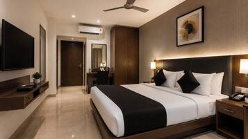A hotel room with a bed, bedside table, lamp, and a ceiling fan.