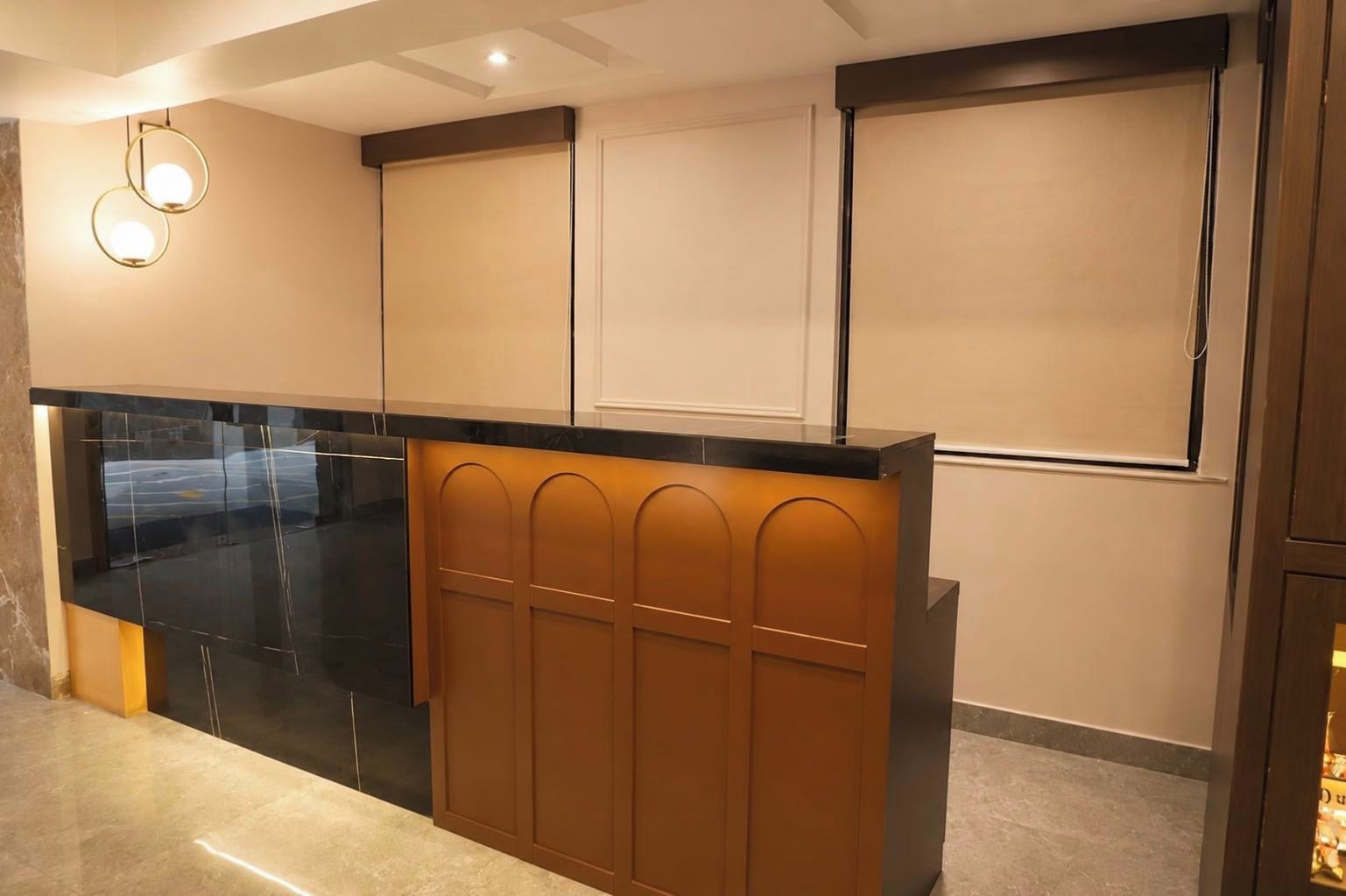 Una cocina moderna con encimera negra, paneles de madera e iluminación empotrada.