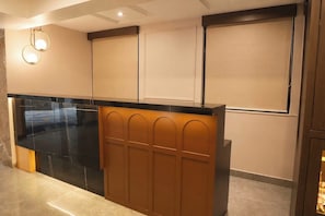 A modern kitchen with a black countertop, wooden paneling, and recessed lighting. - Palette Hotel Whitefield, Nallurhalli (Bangalore)