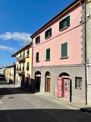 A street with buildings, a clear sky, and a visible parking sign. - Vrbo Property (Riparbella)