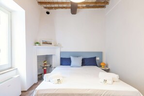 A hotel room with a bed, a small table with a lamp, a fireplace, and a window. - Nice apartment for 4 guests with A/C, WIFI, close to Assisi (Bevagna)