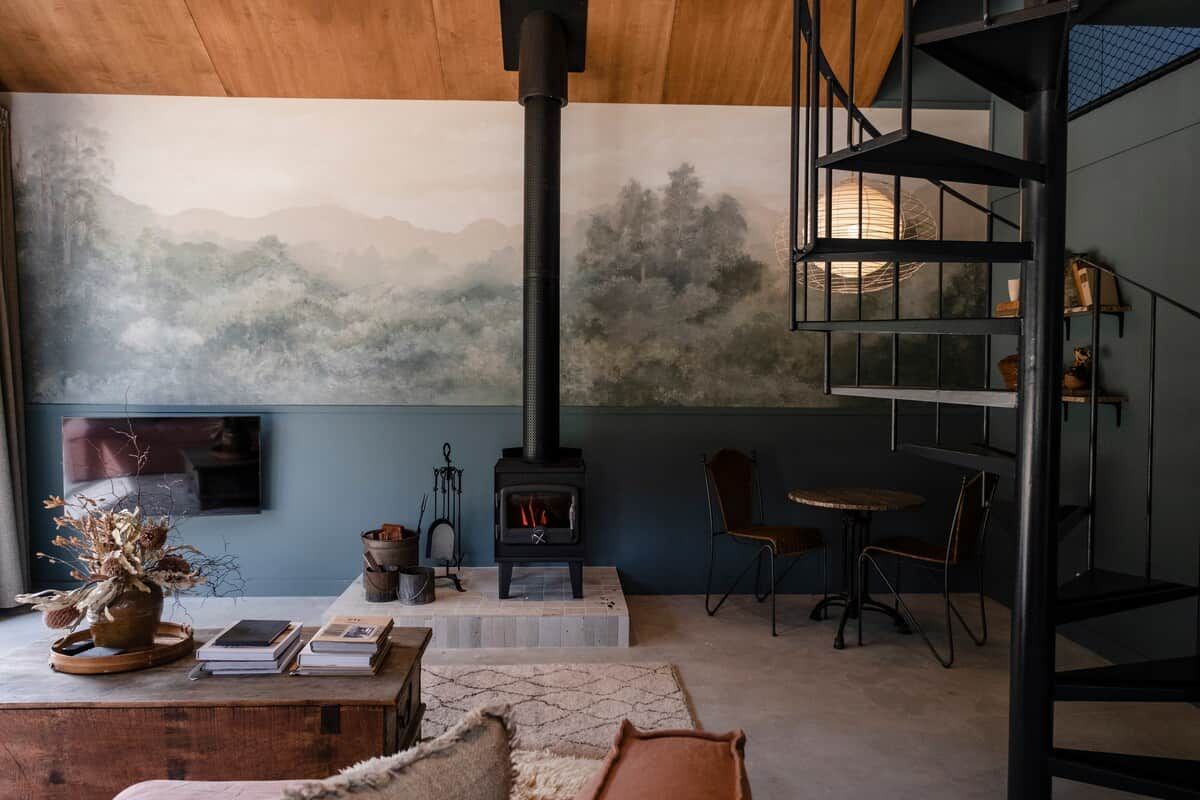 A cozy interior with a fireplace, a bookshelf, and a comfortable seating area.