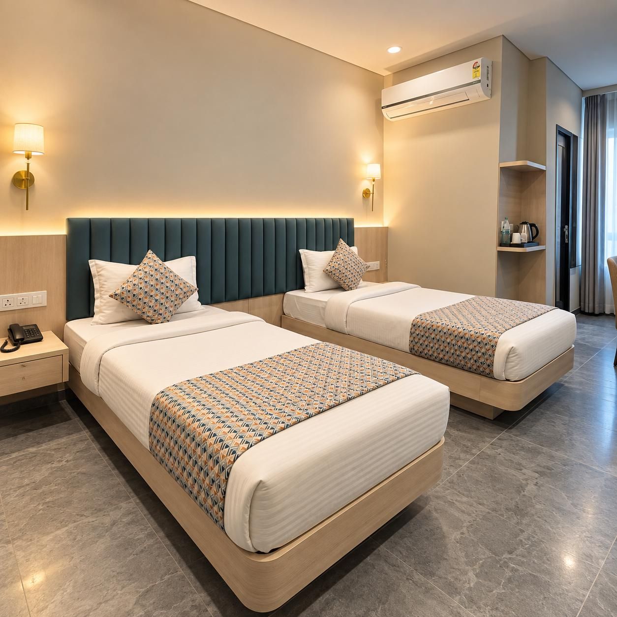 A hotel room with two beds, a bedside table with a phone, an air conditioning unit, and a lamp.