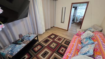 Ein Schlafzimmer mit einem Bett, einem Fernseher, einem Schreibtisch und einem Spiegel.