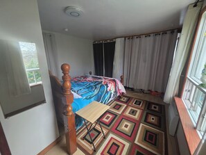 A bedroom with a bed, a window, curtains, a radiator, and a patterned rug. - Cozy Updated Campbellton Studio. Sleeps 4 + Free Parking + Laundry Available. (Campbellton)