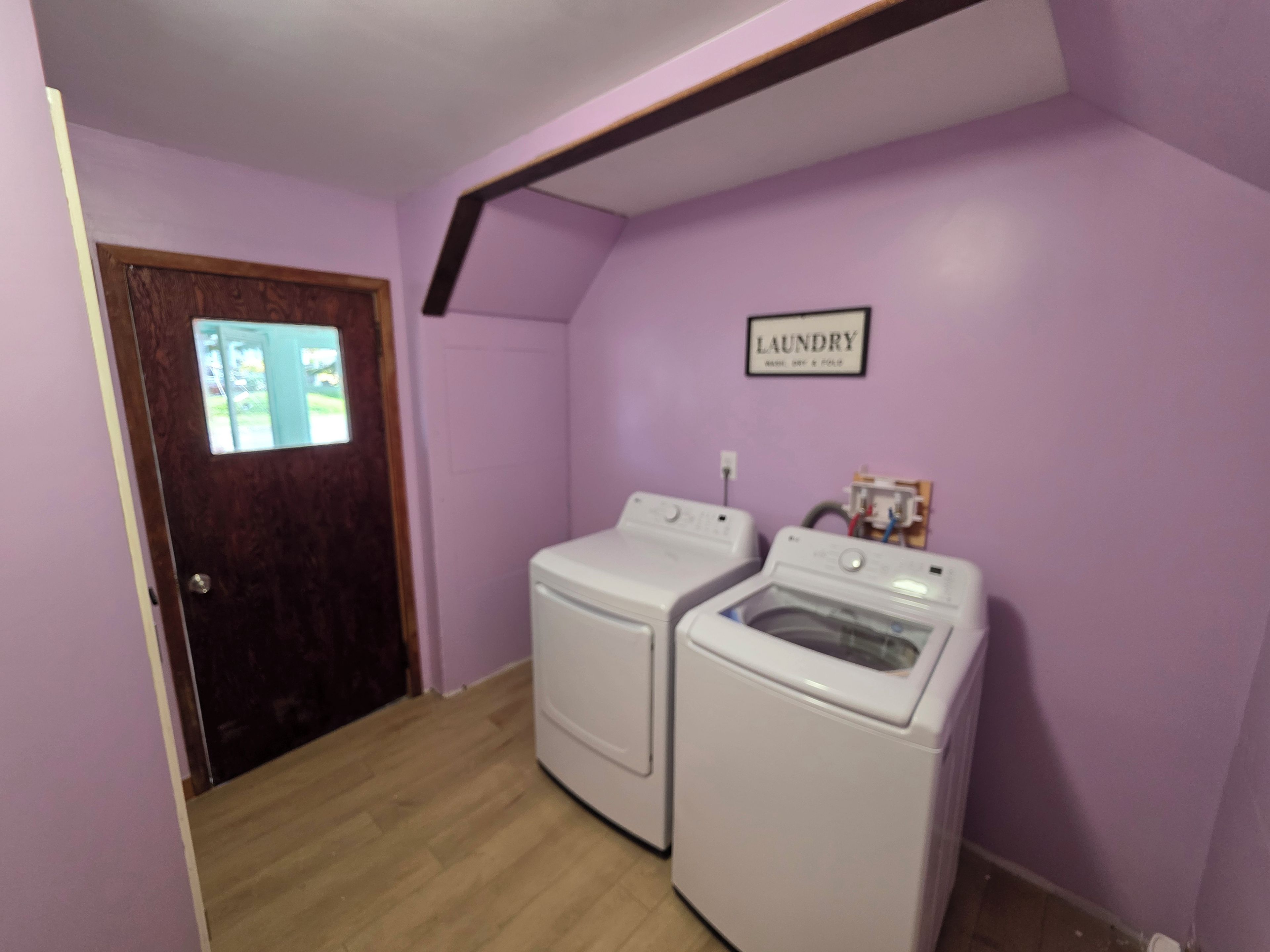 Una sala de bugaderia amb dues rentadores i un cartell que diu 'LAUNDRY'.