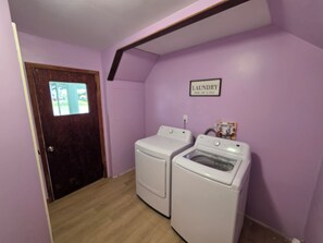 A laundry room with two washing machines and a sign that says 'LAUNDRY'.