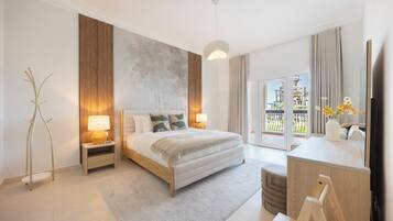 Habitación de hotel moderna con cama, lámparas de noche, un amplio ventanal y vistas a un área exterior.