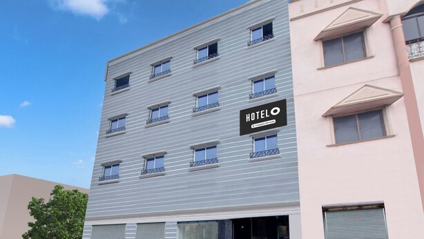 A multi-story hotel building with a sign indicating it is company-serviced. - Hotel O Vijayawada Near Railway Station (Vijayawada)