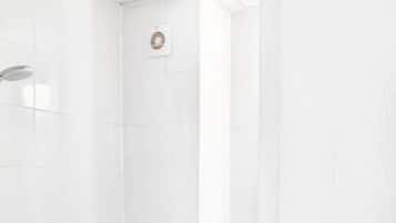Ein Badezimmer mit Toilette, Dusche und Handtrockner.