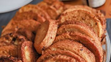 Una bandeja con tortitas doradas dispuestas sobre un recipiente metálico.