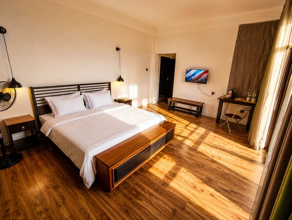 A hotel room with a bed, bedside tables, a TV, a desk, and a bench. - Claython hills ella (Ella)