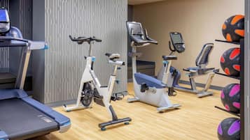 A gym with stationary bikes, treadmills, and exercise balls.